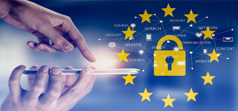 Una mano regge un cellulare che è puntato verso un lucchetto circondato dalle stelle della bandiera europea.