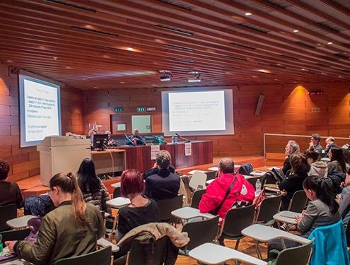 Foto di una sala conferenze affollata di partecipanti al seminario.